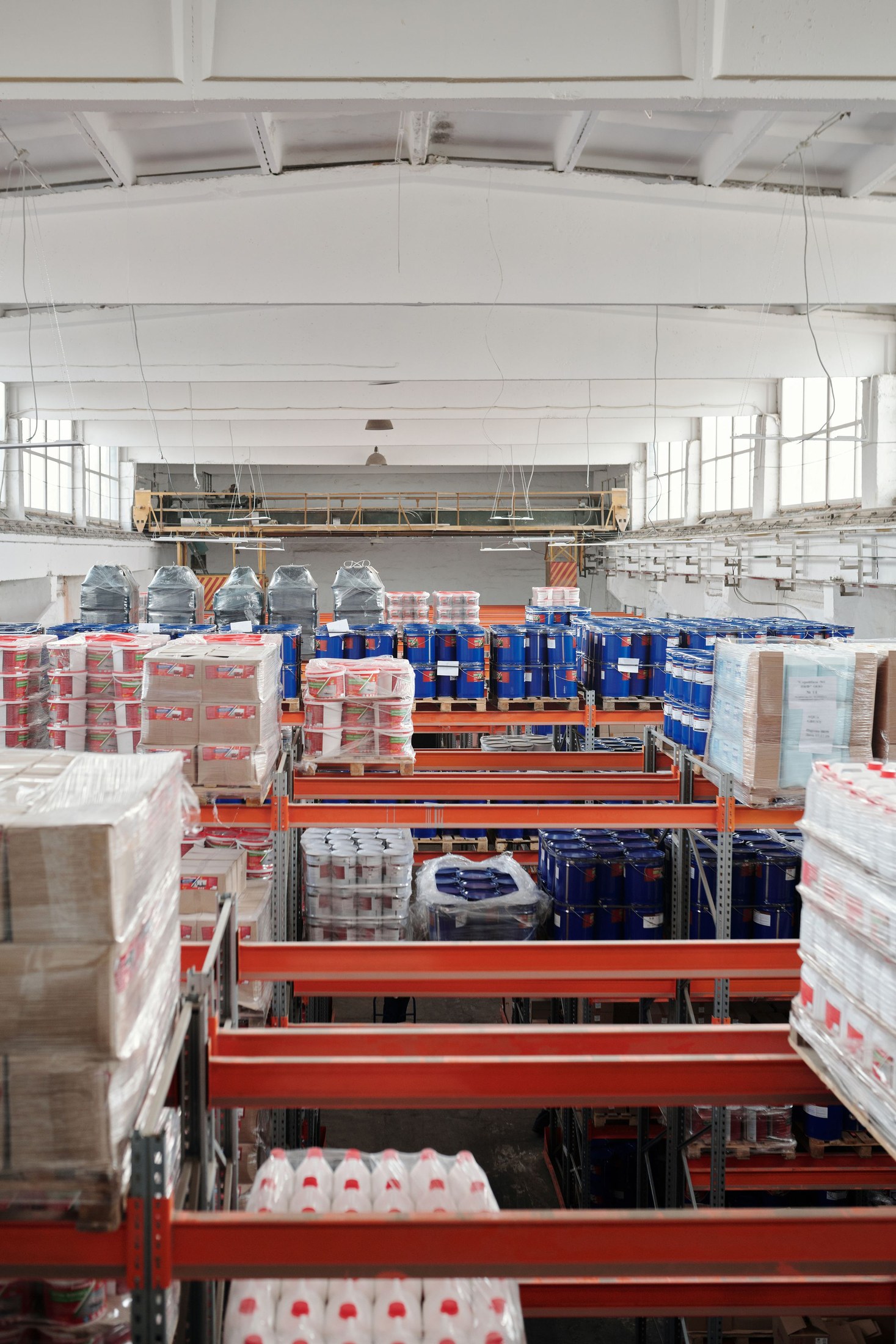 Tall warehouse shelves holding organized cartons and palletized goods